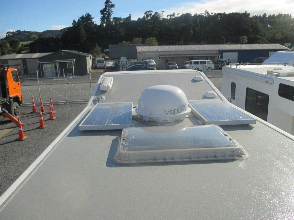 Motorhome roof repaint close-up with solar panels
